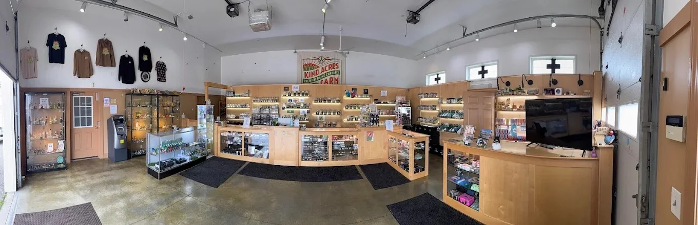 Panorama of the Kind Acres Farm shop floor — display cases, lit product shelves, farm merch on the wall and the front counter