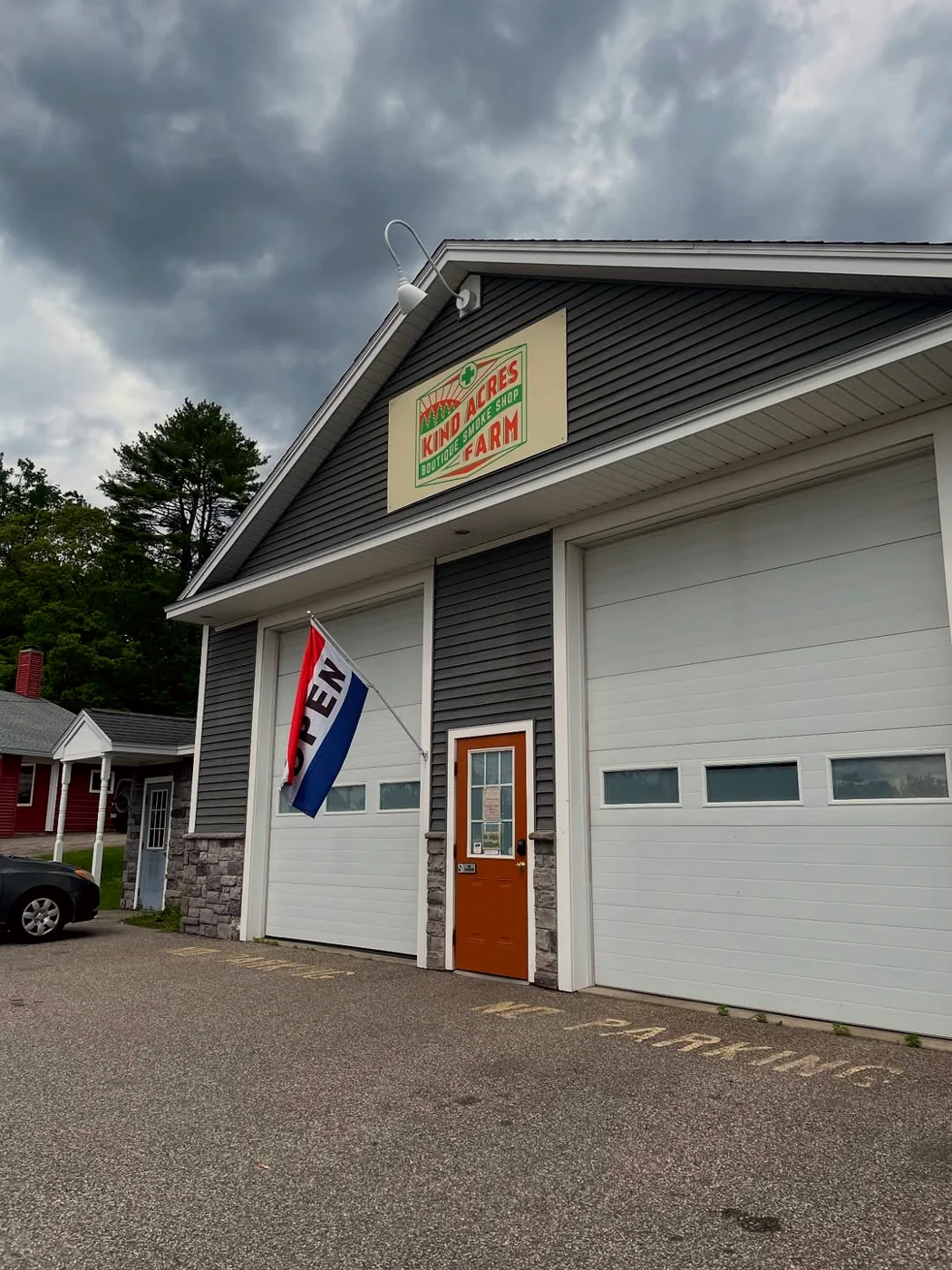 The Kind Acres Farm storefront in Biddeford — KIND ACRES FARM boutique smoke shop sign, OPEN flag flying